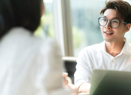 man in formal shirt talking to a woman looking happy